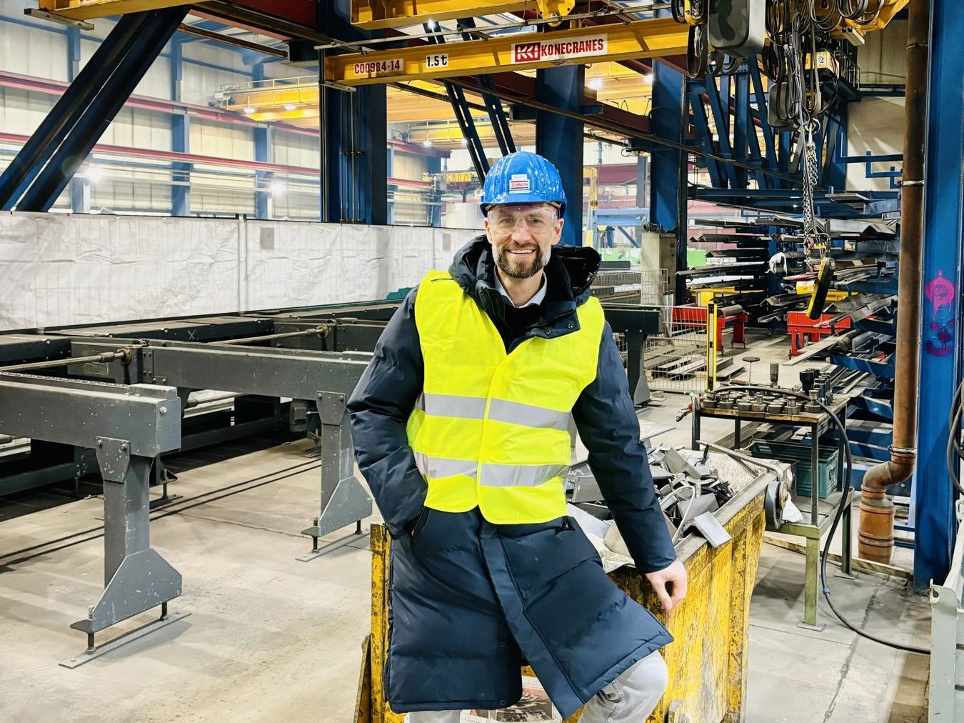 Nico Hollbauer mit Helm und Warnweste im Produktionsbetrieb